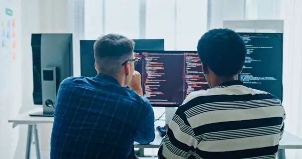 A software team collaborating around laptops and a project board